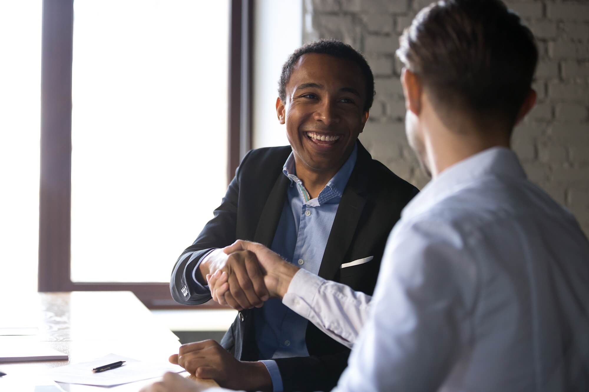 A business owner and a client shake hands.